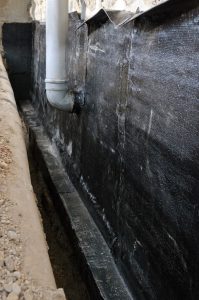 Basement waterproofing membrane being installed around a foundation in Mt Prospect, Illinois